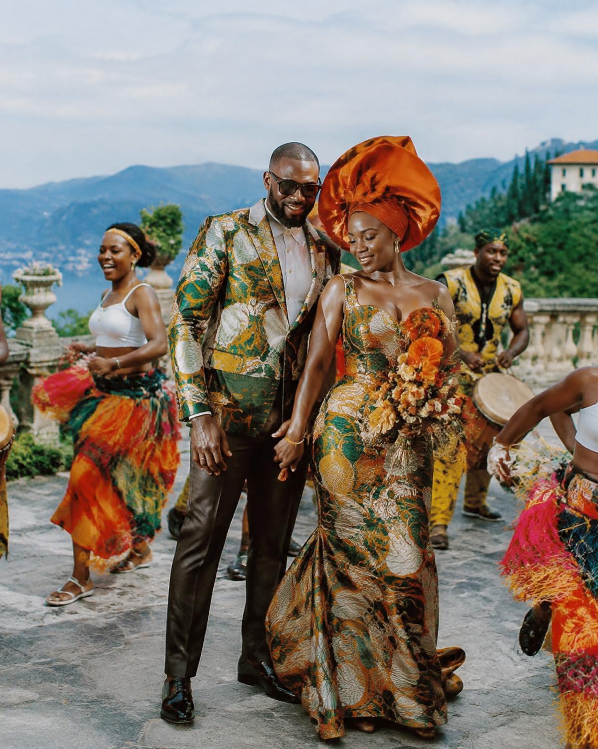 African wedding couple in modern Ankara-inspired couture with drummers on a villa terrace
